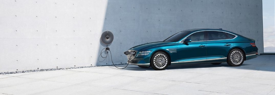 Blue 2022 Genesis Electrified G80 in a Driveway Charging