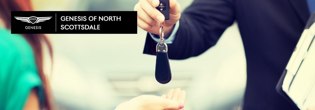 Dealer Handing Keys to a Woman with Earnhardt Genesis of North Scottsdale Logo
