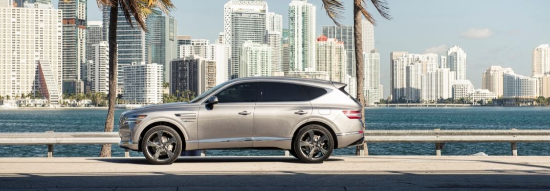 Silver 2021 Genesis GV80 Side Exterior Parked Next to Water and Palm Trees