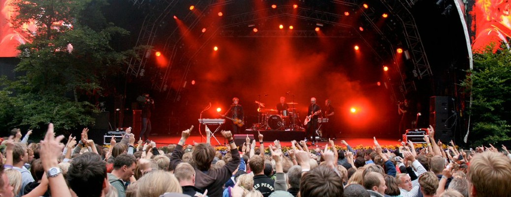 A crowd in front of a live band at an outdoor venue