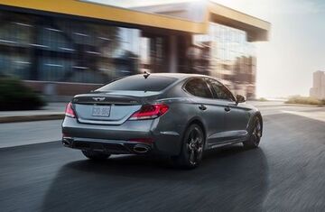 Genesis G80 driving on a city street.