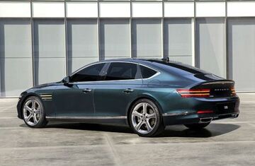 Rear view of a Genesis G80 parked in front of a modern building.