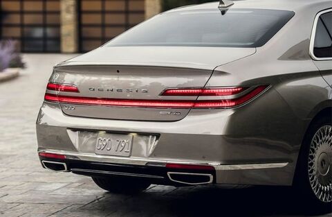 Rear view of a silver Genesis G90 parked in a driveway.