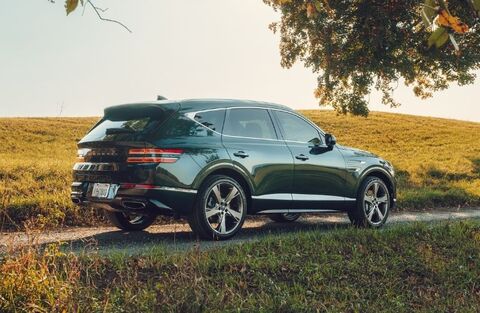 Genesis GV80 parked on a grassy road.