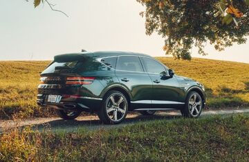 Genesis GV80 parked on a grassy road.