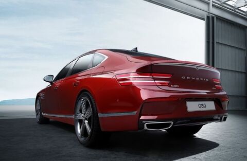 Rear view of a red Genesis G80 parked in a garage.