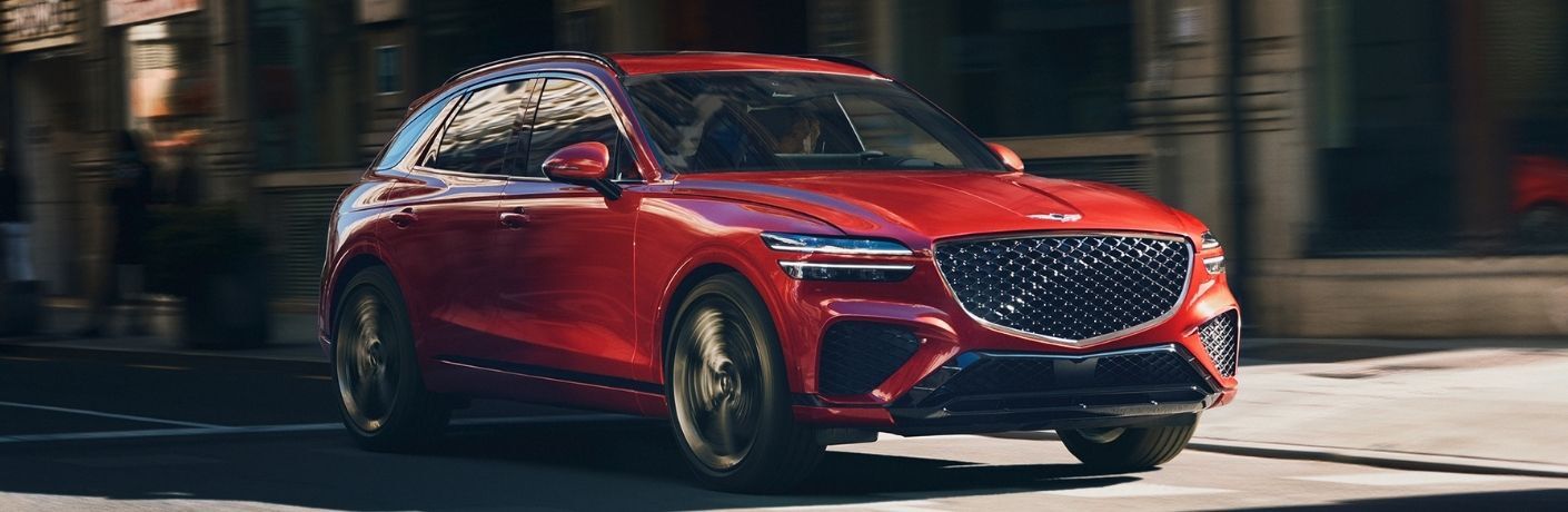 Genesis GV70 driving through a city street.