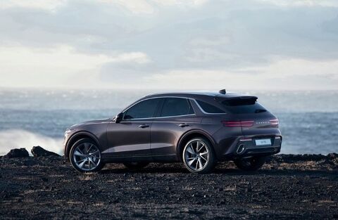 Genesis GV70 parked on a rocky cliff overlooking the ocean.