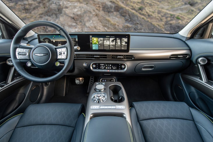 Interior of a Genesis GV60, featuring a large touchscreen display and leather seats.