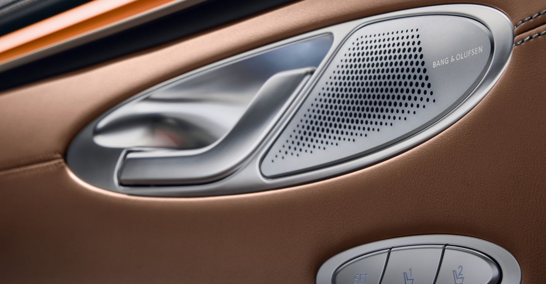 A close-up of a luxury car's interior door panel—specifically an Aston Martin DBX.