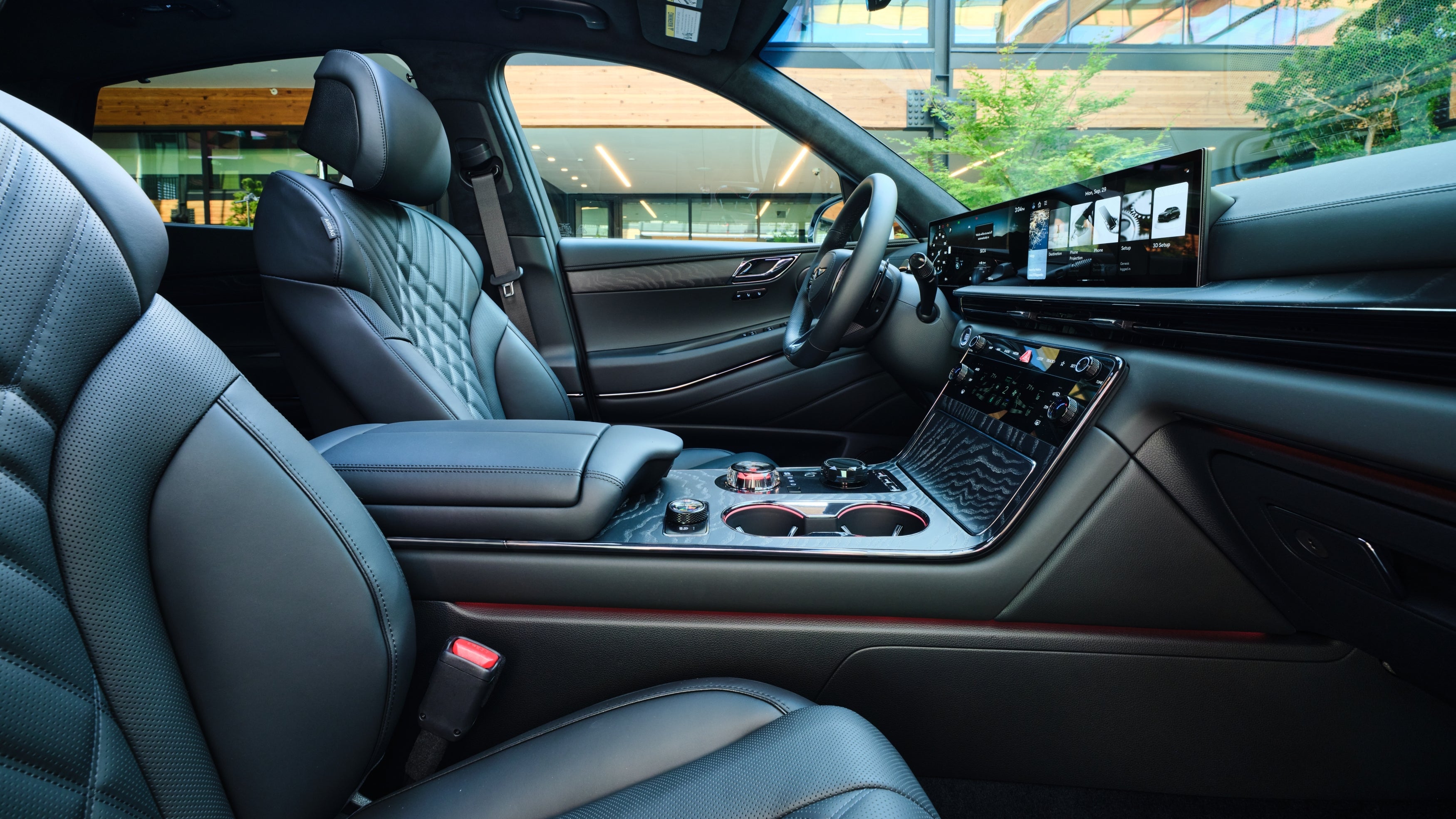 The spacious obsidian black interior of the 2026 Genesis GV80 Coupe is seen looking sideways towards the driver's seat from the front passenger's seat.