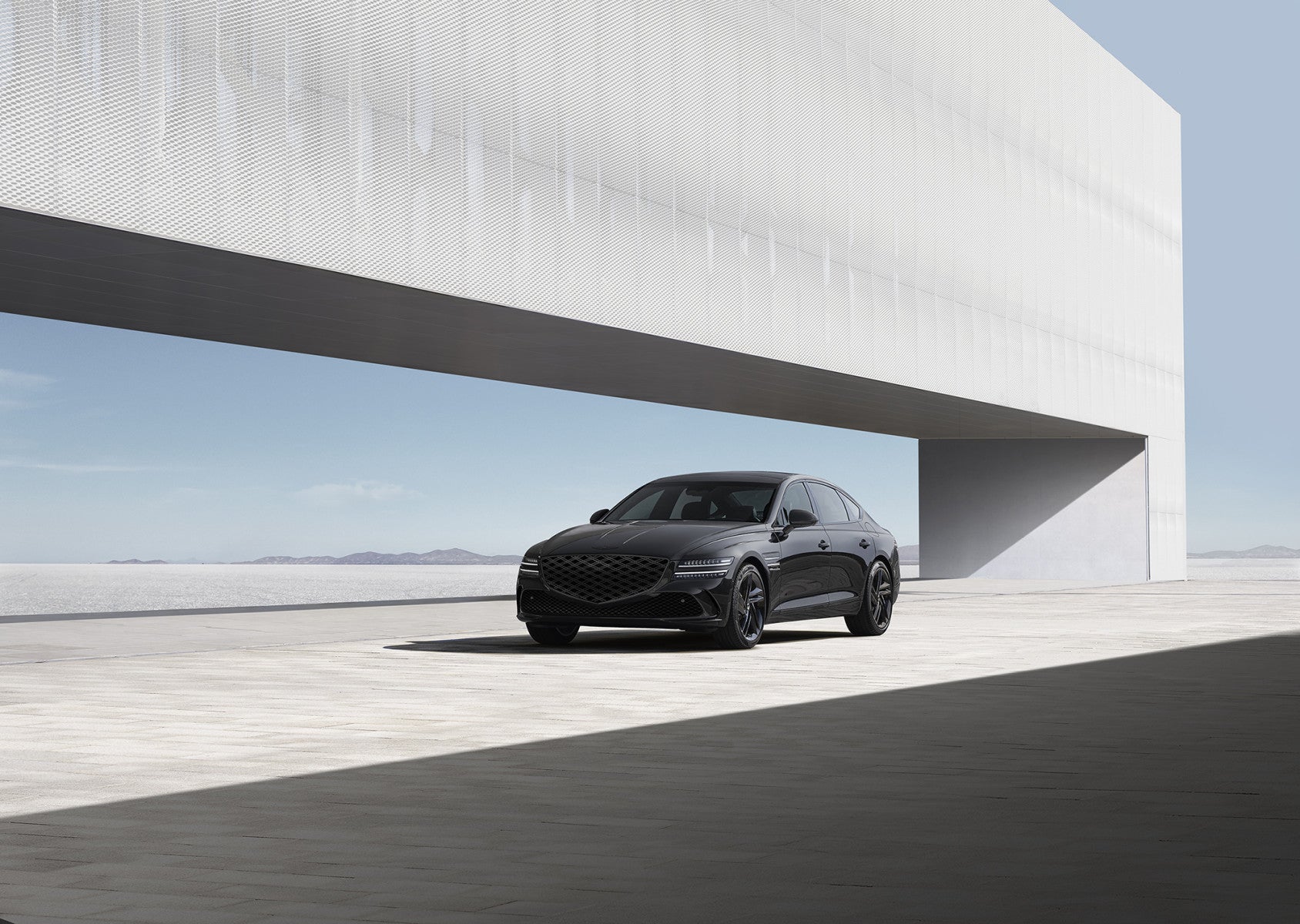 A black 2026 Genesis G80 in Scottsdale is parked facing the viewer to the left on a white concrete platform high in the sky.
