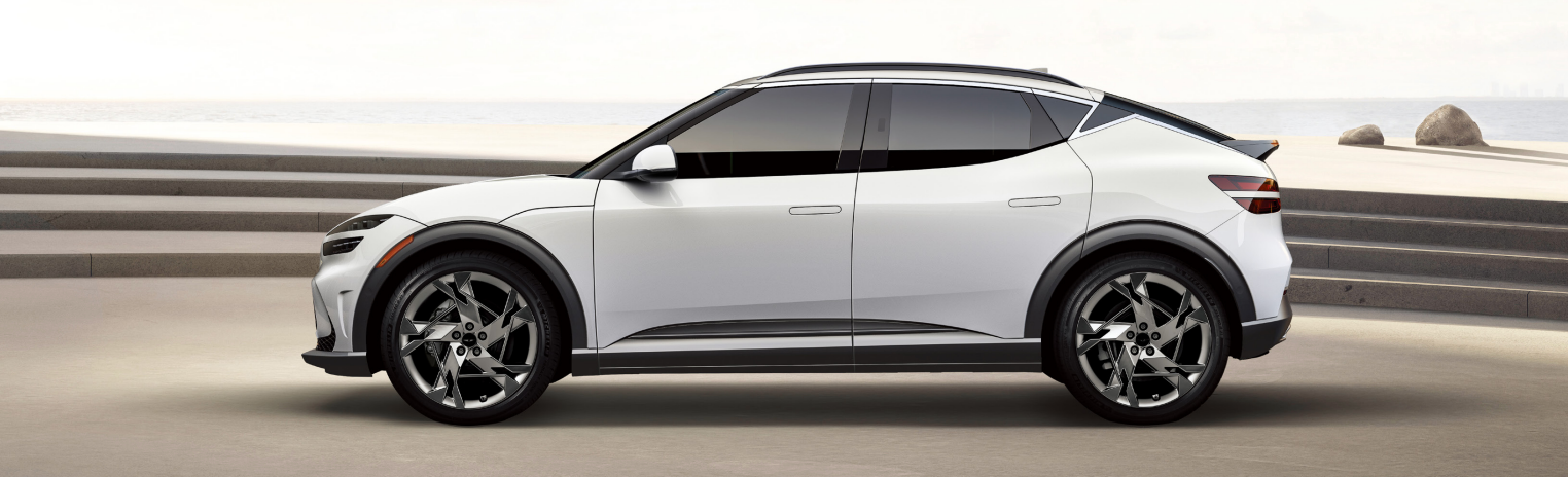 A white Genesis X Convertible parked on a beach.