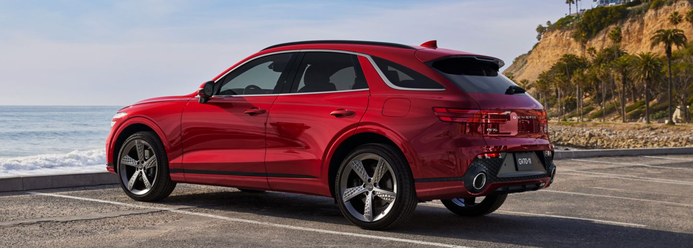Red Genesis GV70 parked by the ocean.
