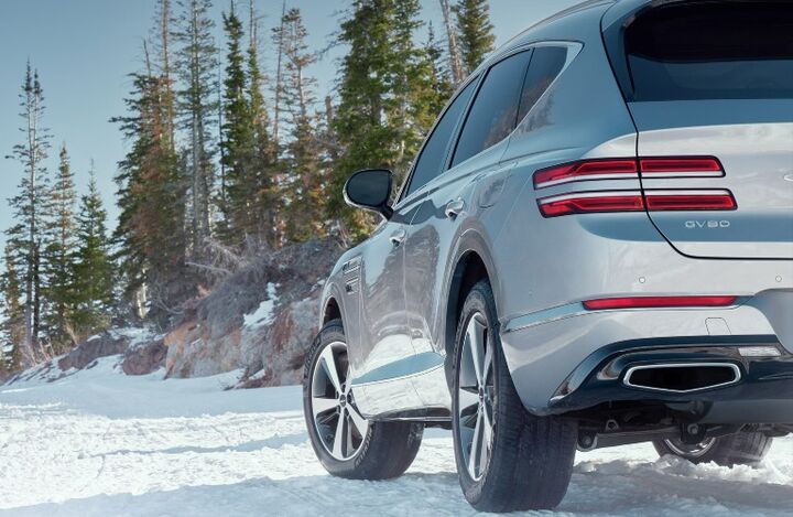 Genesis GV80 driving on a snowy road.