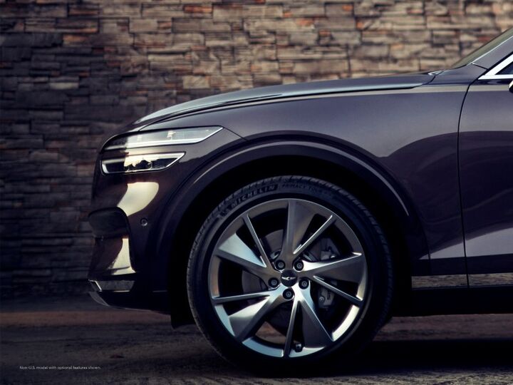 Close-up of a Genesis GV70 wheel and headlight.