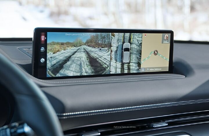 A car dashboard with a large display showing a 360-degree camera view and a navigation map.
