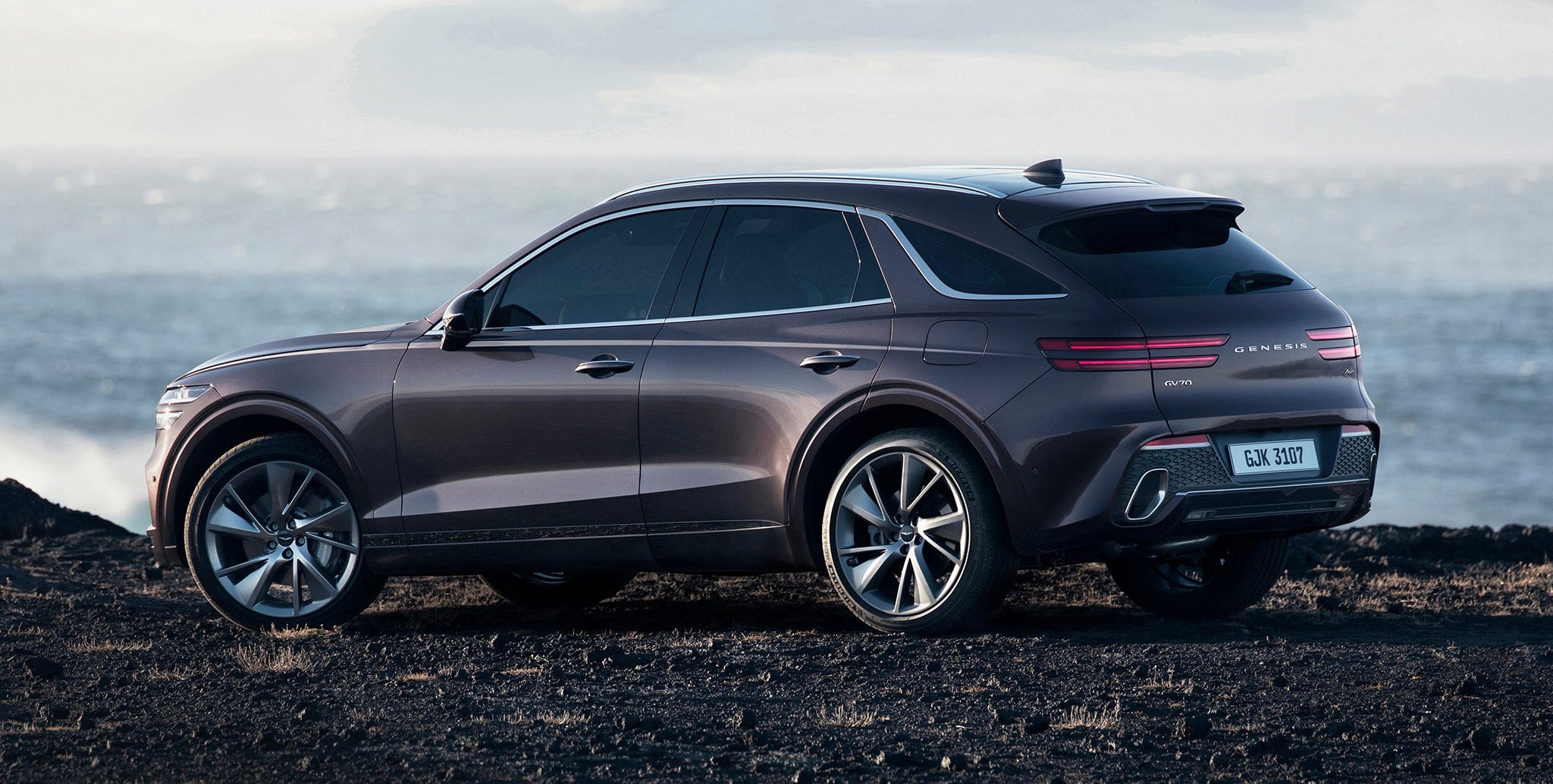 Genesis GV70 parked on a cliff overlooking the ocean.